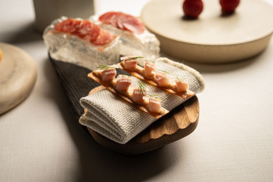 Pan de cristal con fuet de porc negre, servido sobre un bloque de hielo