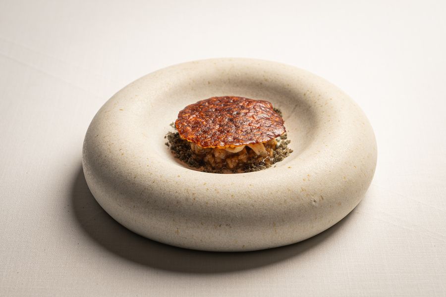 Un bocado crujiente sobre un plato circular de cerámica blanca