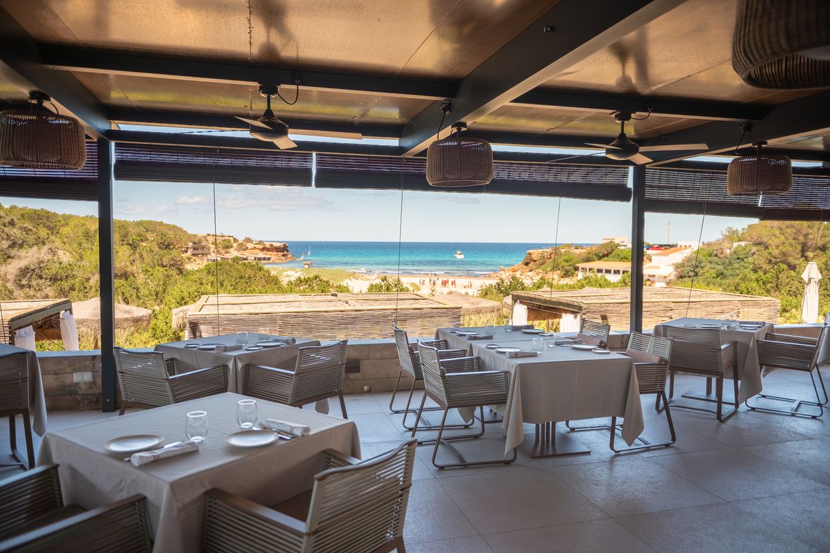 El comedor de Cala Saona Ramón Freixa abierto a la playa, con el mar turquesa al fondo