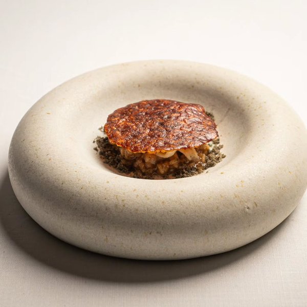 Espardeñas, arroz y socarrat en un plato de cerámica clara