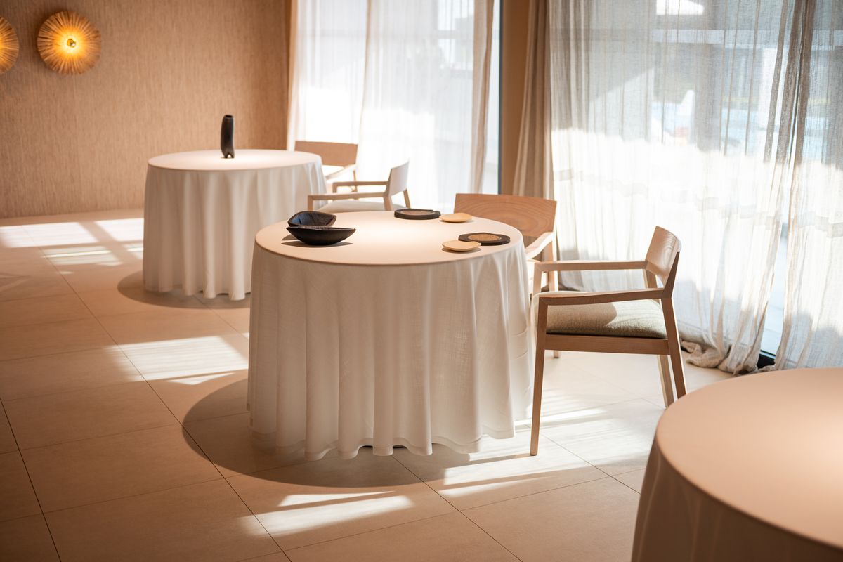 La sala de Sol Post con dos mesas redondas vestidas y luz de tarde